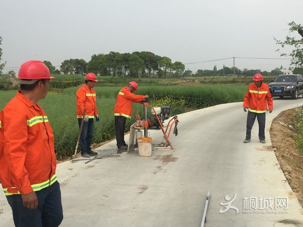 工程技术人员在孔城镇王店村汪庄路上进行检测作业.jpg