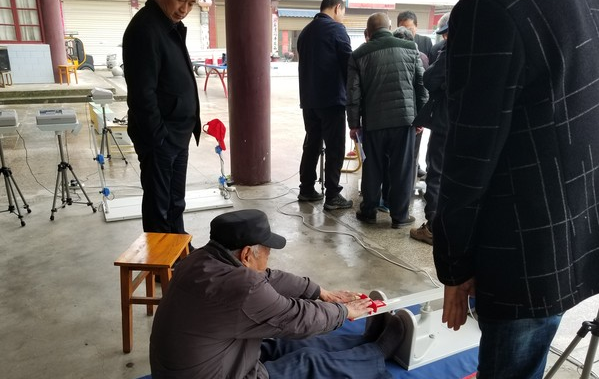图为一老人在测量坐位体前屈项目.png