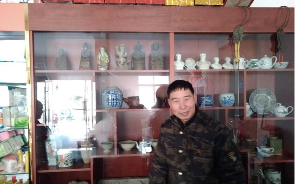 图为汪张根和他的古玩柜台.png