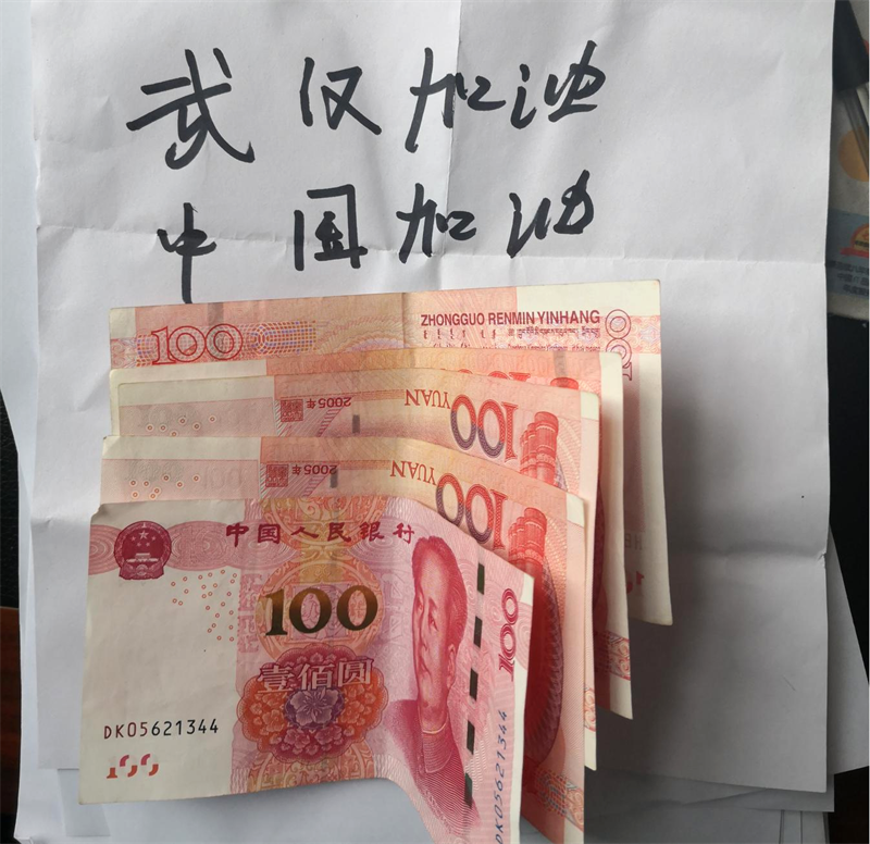 图为捐款人留下的现金和字条.