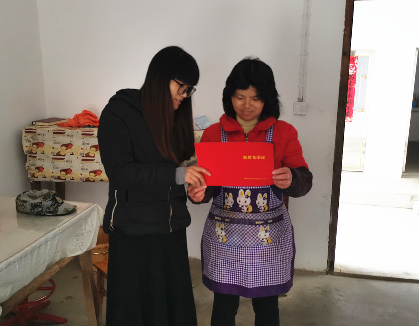 图为包组干部为徐三英（右边）颁发脱贫光荣证.jpg