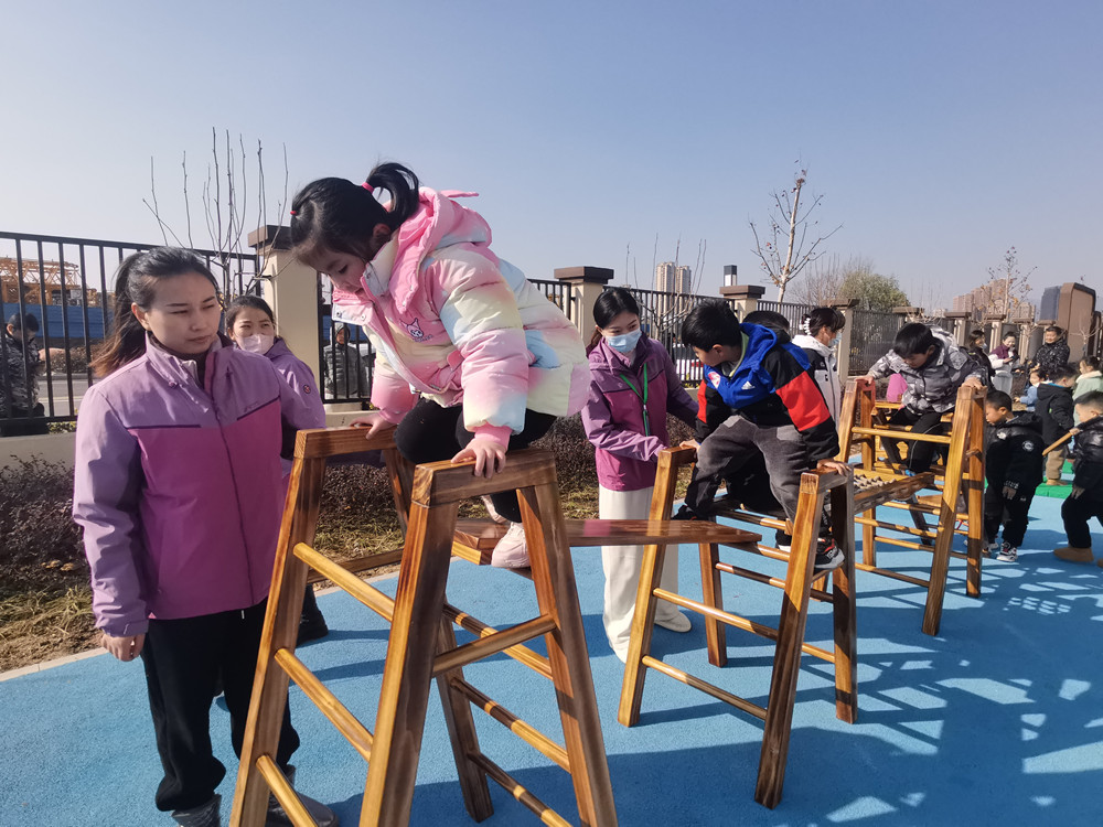 图为小朋友们在老师陪伴下进行户外游戏活动3.jpg