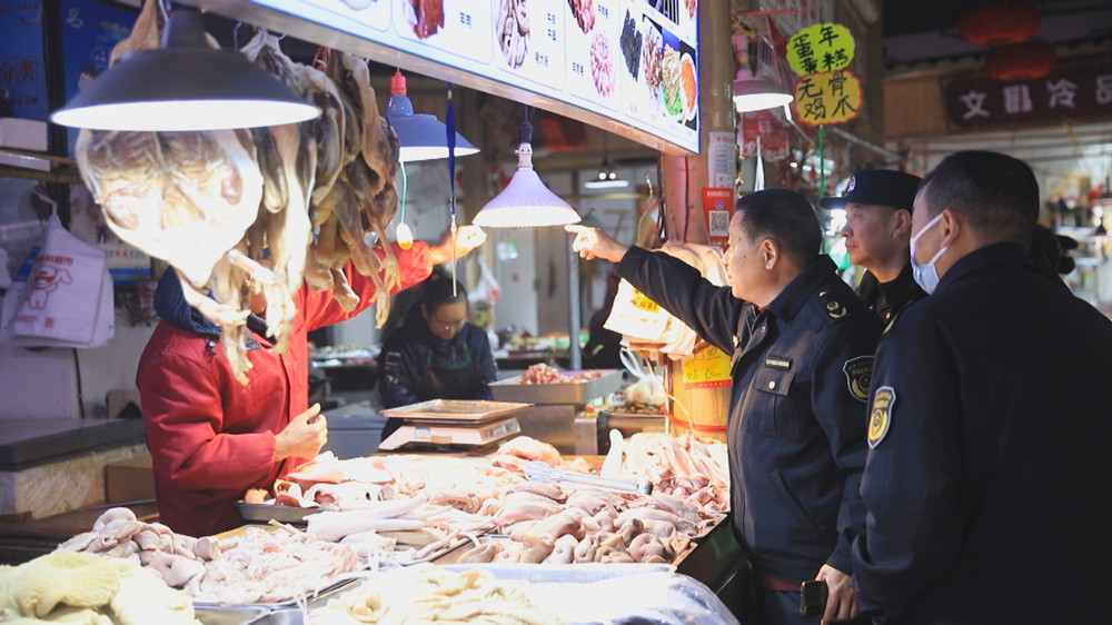 图为联合检查组工作人员正在对某农贸市场内有无使用生鲜灯情况进行检查.jpg