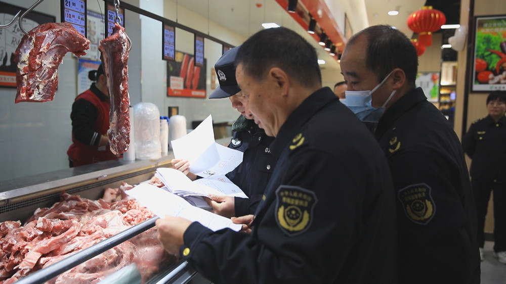图为联合检查组工作人员正在查验某商超肉类食品检验检疫合格证等单据.jpg