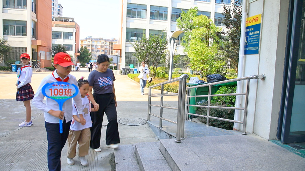 图为校园红领巾志愿者正在带领一年级新生进行开学报到.jpg