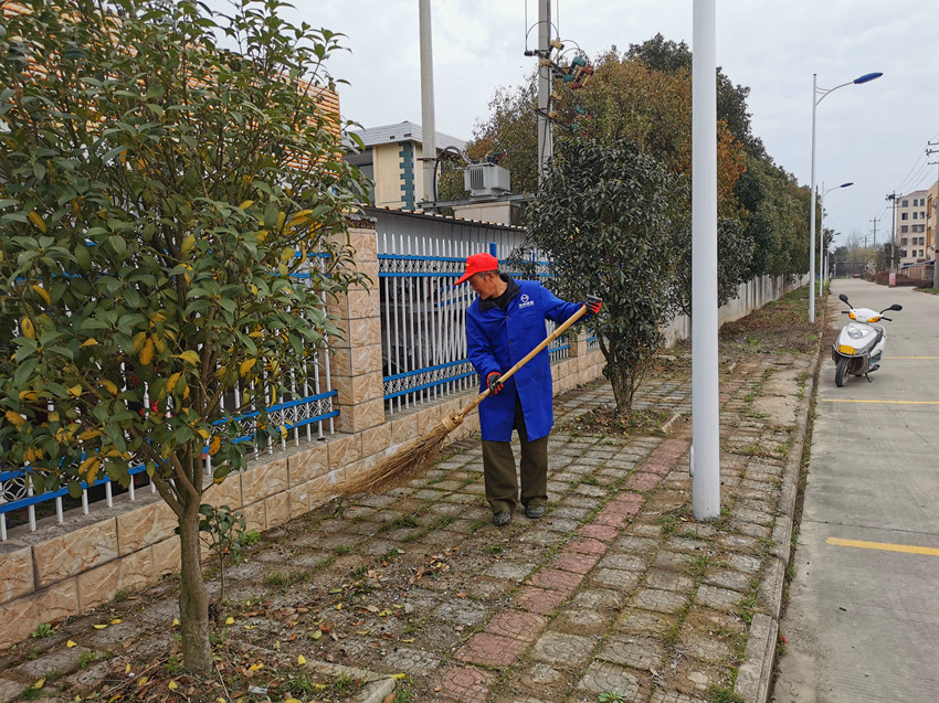图为王本胜正在清扫路面.jpg