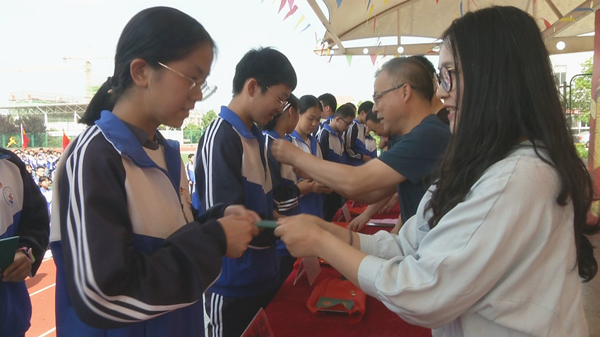 实验中学为新入团成员佩戴团徽发放团员证.jpg