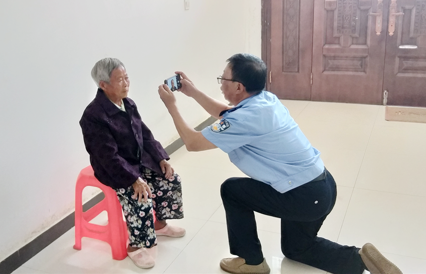 图为民警为老人拍摄身份证照片.png